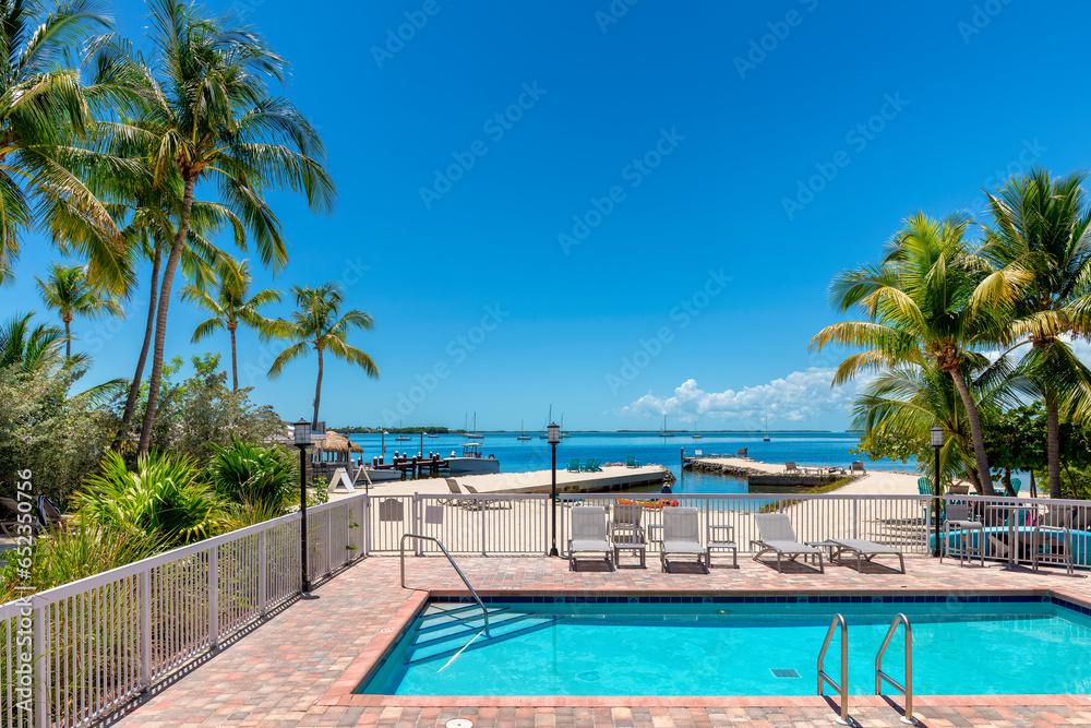 Palm trees and pool with beach loungers in tropical beach resort in tropical island, Key Largo. Florida Palm trees and pool with beach loungers in tropical beach resort in tropical island, Key Largo. Florida
