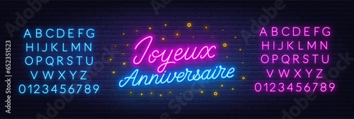 Joyeux Anniversaire neon lettering on brick wall background. Happy Birthday in French