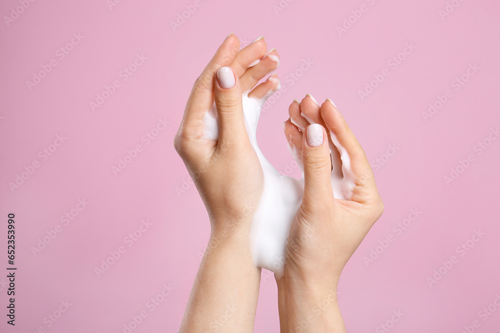 Woman washing hands with cleansing foam on pink background, closeup. Skin care cosmetic - obrazy, fototapety, plakaty 