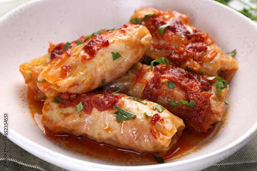 Delicious stuffed cabbage rolls cooked with homemade tomato sauce on table, closeup