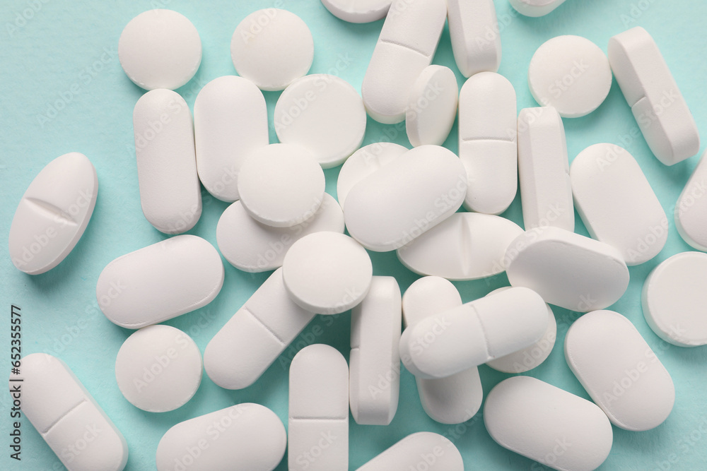 Many white pills on mint background, flat lay Many white pills on mint background, flat lay