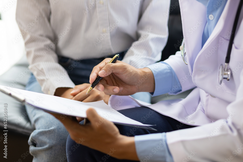 Doctor diagnosing a woman's illness in a hospital examination room, disease treatment from specialists. Medical treatment and health consultation. General health checkups and women's health problems.