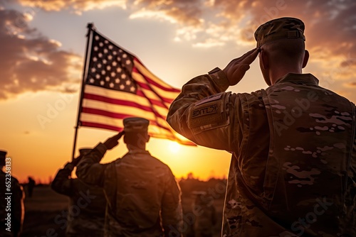 US Army soldiers salute against the backdrop of sunset and the US flag photo