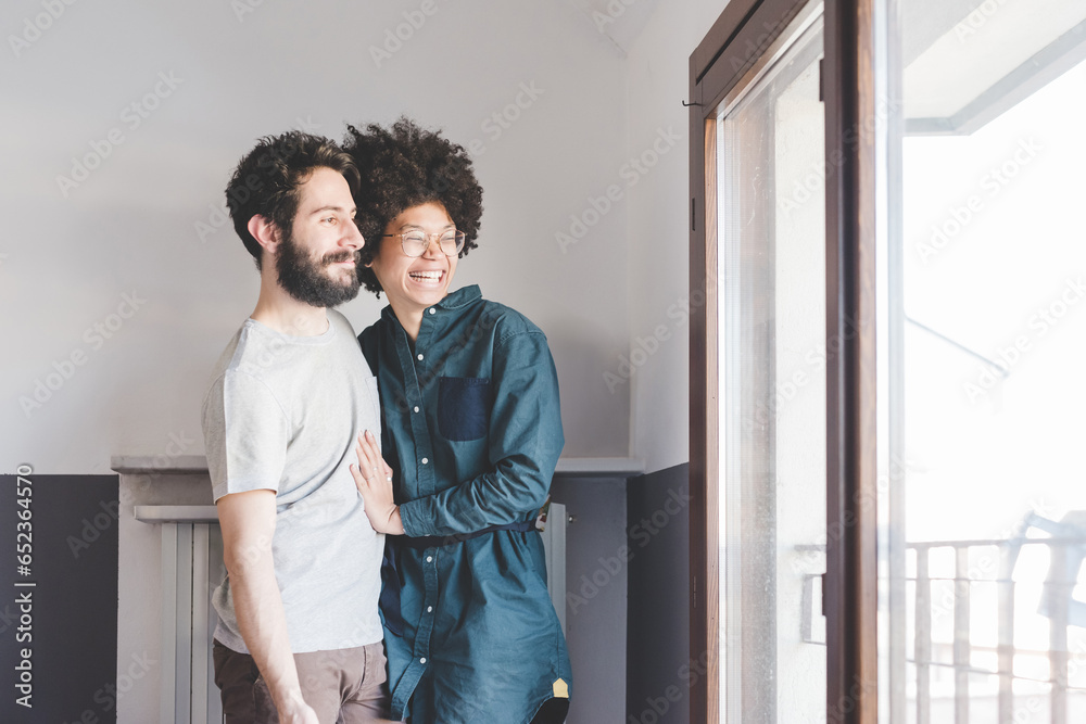 Young multiethnic couple hugging smiling indoor Young multiethnic couple hugging smiling indoor