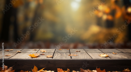 Golden autumn leaves background with bokeh and empty wooden table for a decoration