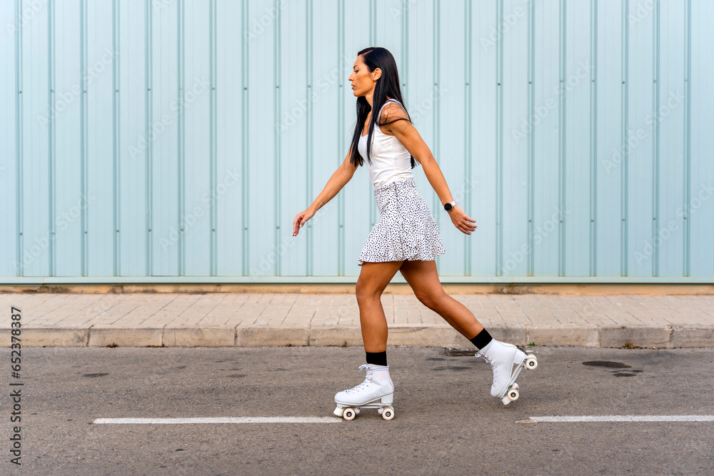 Obraz premium Portrait of a young girl roller skating on the street
