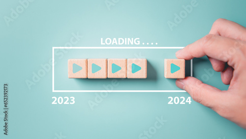 2024 New Year countdown loading. Loading bar on wooden blocks 2023 to 2024 on blue background. The beginning of the starting goal and action plan concept. photo