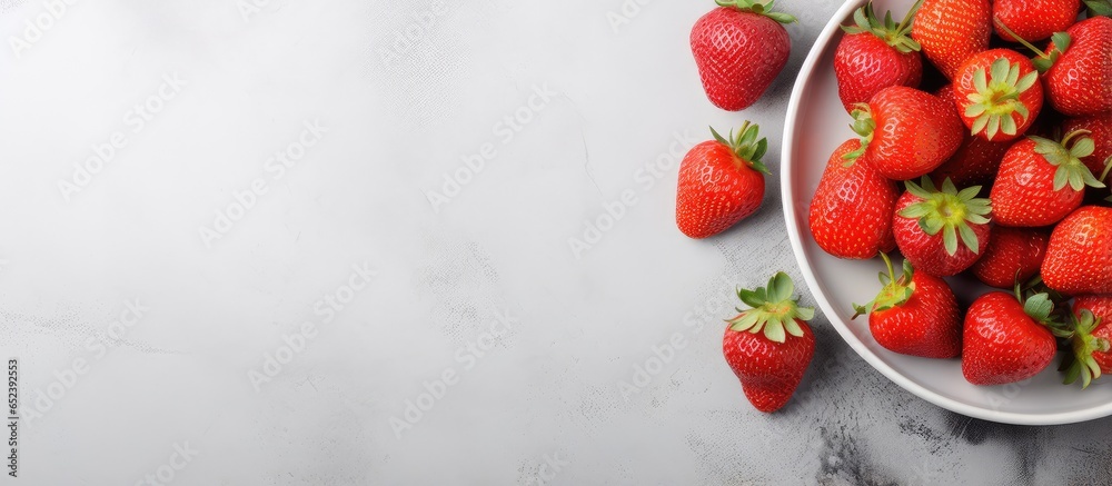 Red juicy berries on a wooden plate detoxifying and vegetarian seen from above isolated pastel background Copy space Red juicy berries on a wooden plate detoxifying and vegetarian seen from above isolated pastel background Copy space