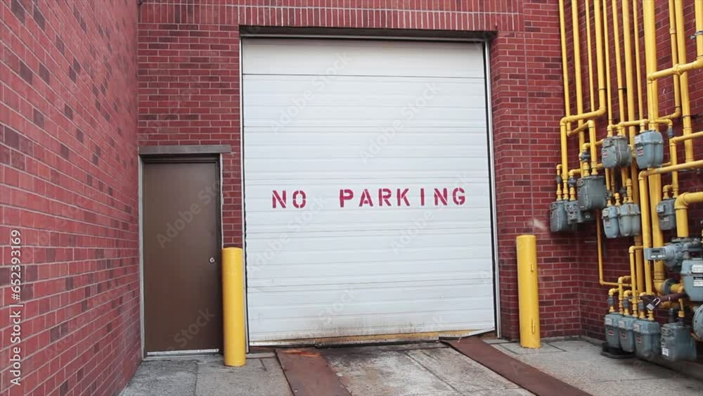 no parking writing caption text on white garage door next to metal