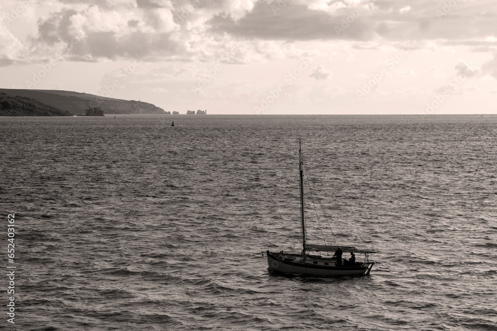 Sailing boat entering harbour and seascape in black and white