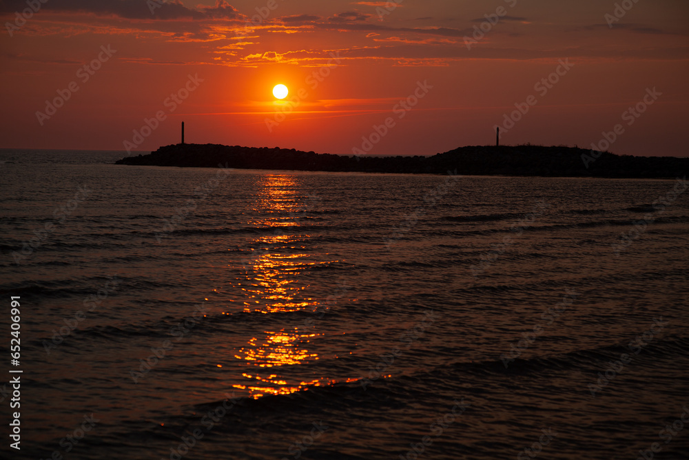 Dark red sunset by the sea. Sunset with pier background. Soft selective focus