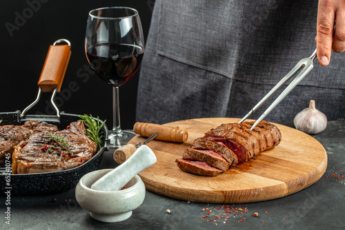beef steaks with wine glass on a dark background. Restaurant menu, dieting, cookbook recipe top view