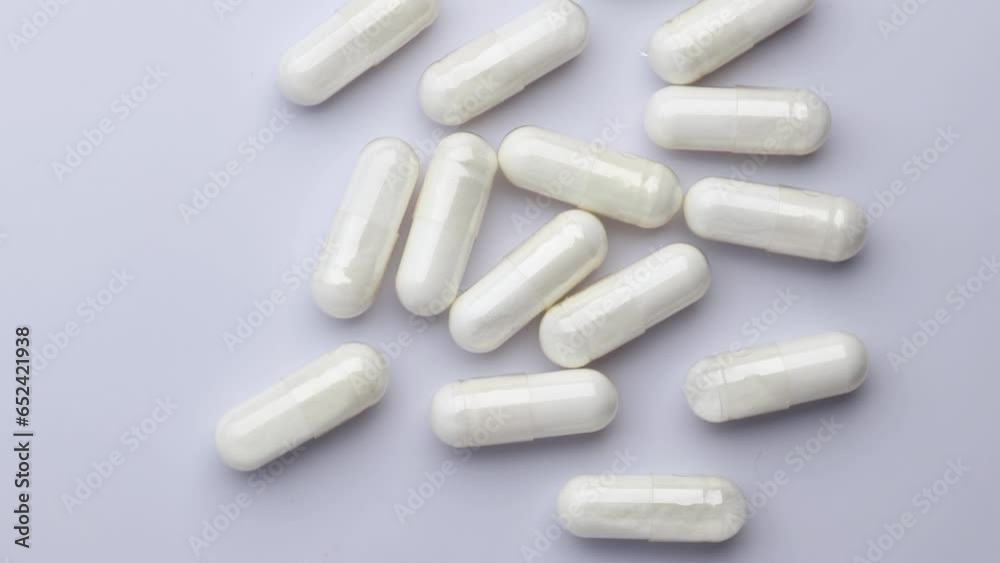 white pharmaceutical capsules, rotation in circle. Collagen capsule on a white background Turning. selective focus. Virus medication concept. vitamin, Medicine chest, top view white pharmaceutical capsules, rotation in circle. Collagen capsule on a white background Turning. selective focus. Virus medication concept. vitamin, Medicine chest, top view
