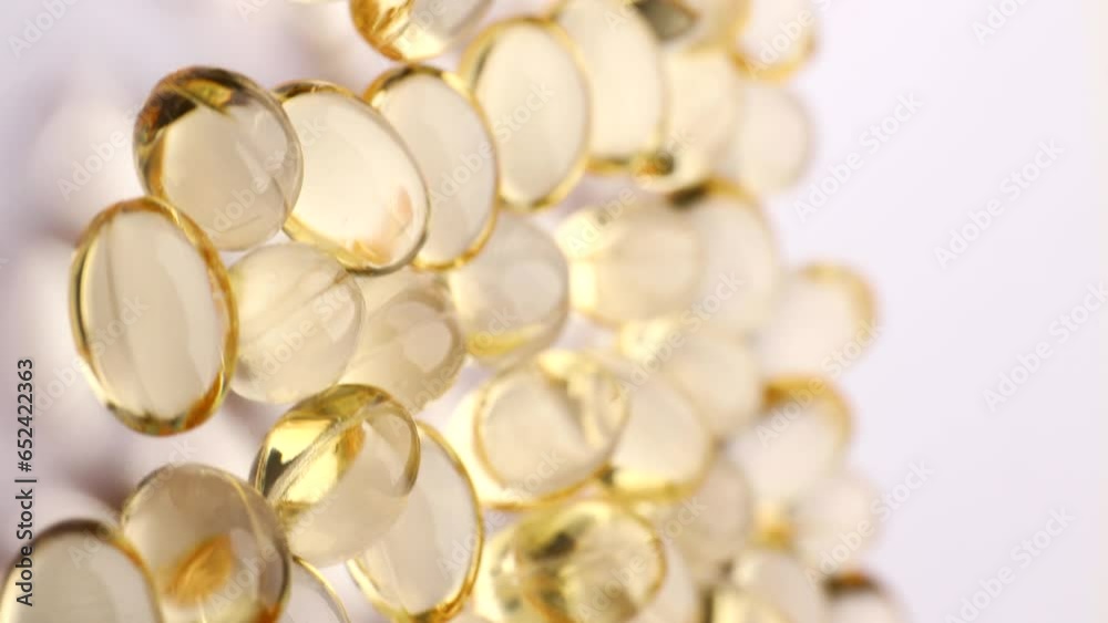 yellow medical capsules, rotation in circle. Vertical video. golden pills containing Vitamin E and Omega 3, fish oil, Turning. concept of medicine. yellow medical capsules, rotation in circle. Vertical video. golden pills containing Vitamin E and Omega 3, fish oil, Turning. concept of medicine.