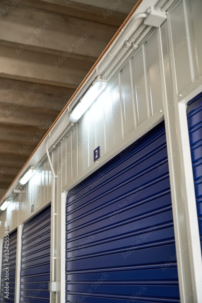 Row of blue roller shutters in modern warehouse
