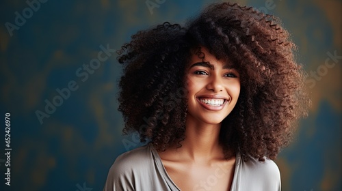 a smiling, laughing Black female model with afro-hair and tribal background, 3/4 view, with space for copy in a product and mock-up Glamour-themed image as a JPG horizontal format. generative ai © Purple Penguin GFX