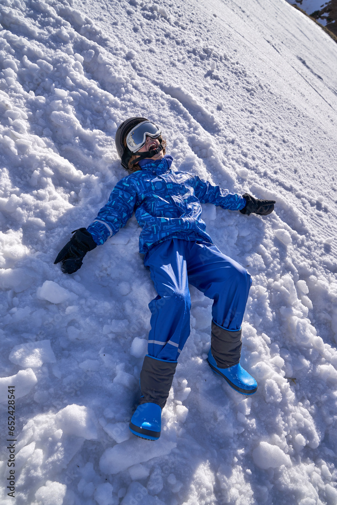 Happy boy making snow angel