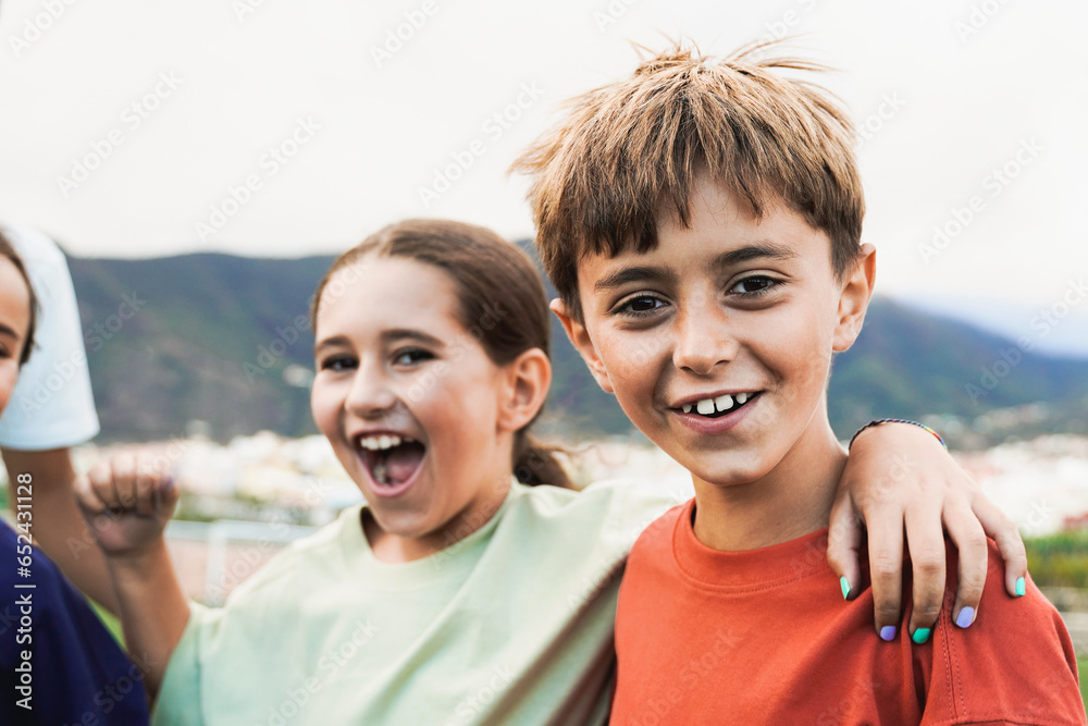 Group of kid friends having fun outside - Latin children celebrating and hugging together - Childhood friendship and life style concept
