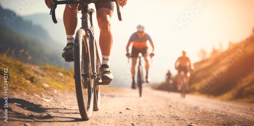 Team of cyclists rides on mountain road,  at sunset photo