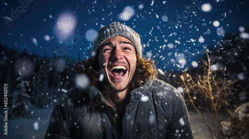 Happy man smiles in the snowfall outside