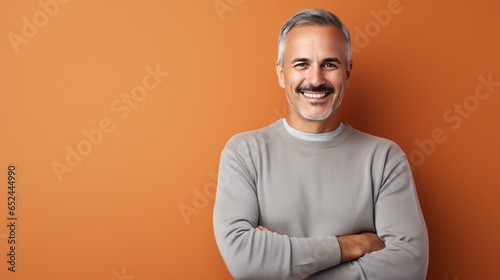 A mature man with a joyful expression in front of a colorful backdrop..