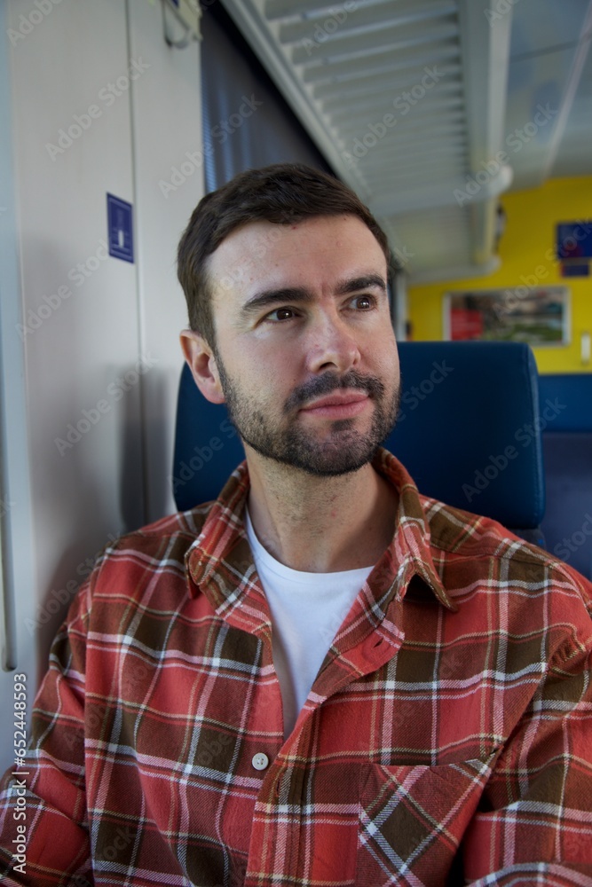 Obraz premium Handsome man sitting on train