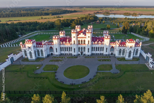 aerial view on overlooking restoration of the historic castle or palace in forest near lake or river photo