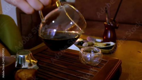 Pouring puerh tea from glass teapot to glass teacup. Chinese tea ceremony. Traditional chinese tea brewing photo