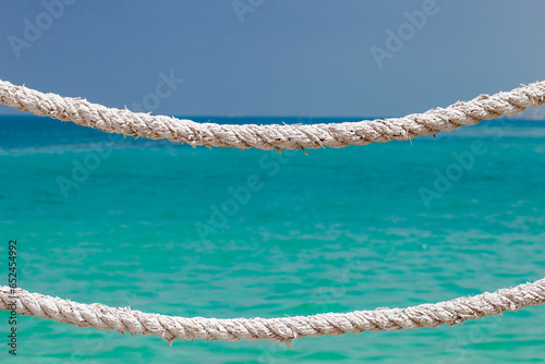 Hemp rope old dried on background of blue sky and sea with turquoise water