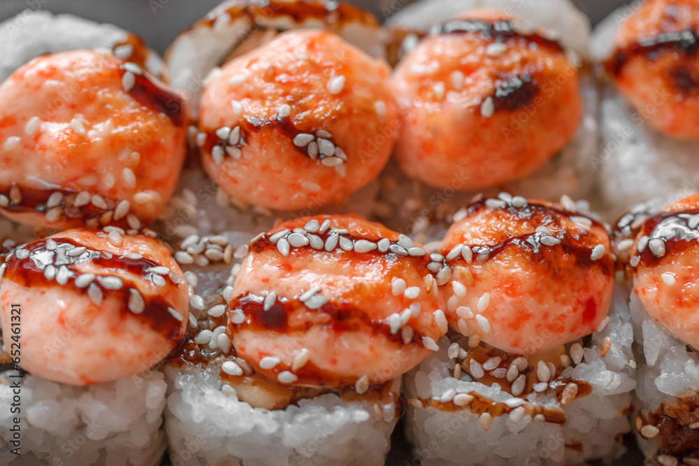 Sushi rolls baked with sesame seeds and with teriyaki sauce, close-up, selective focus