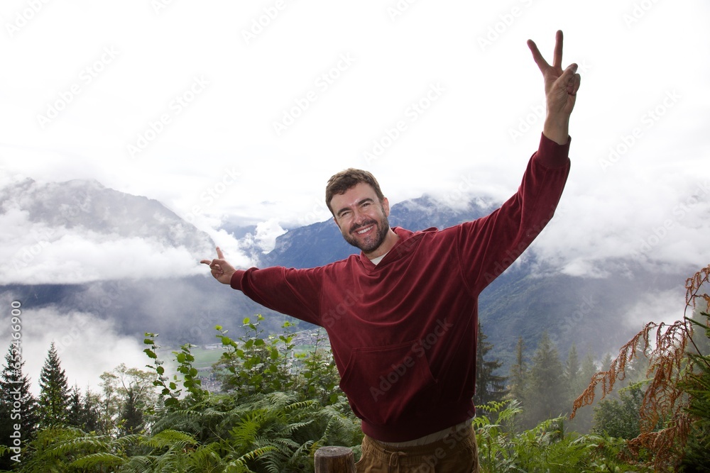 Man doing the peace hand sign at the top of a mountain Man doing the peace hand sign at the top of a mountain