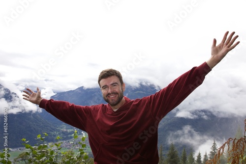 Man raising arms in high mountain top 