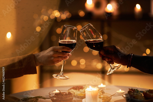 Billede på lærred Close up of two people toasting with wine glasses at dinner table with Christmas