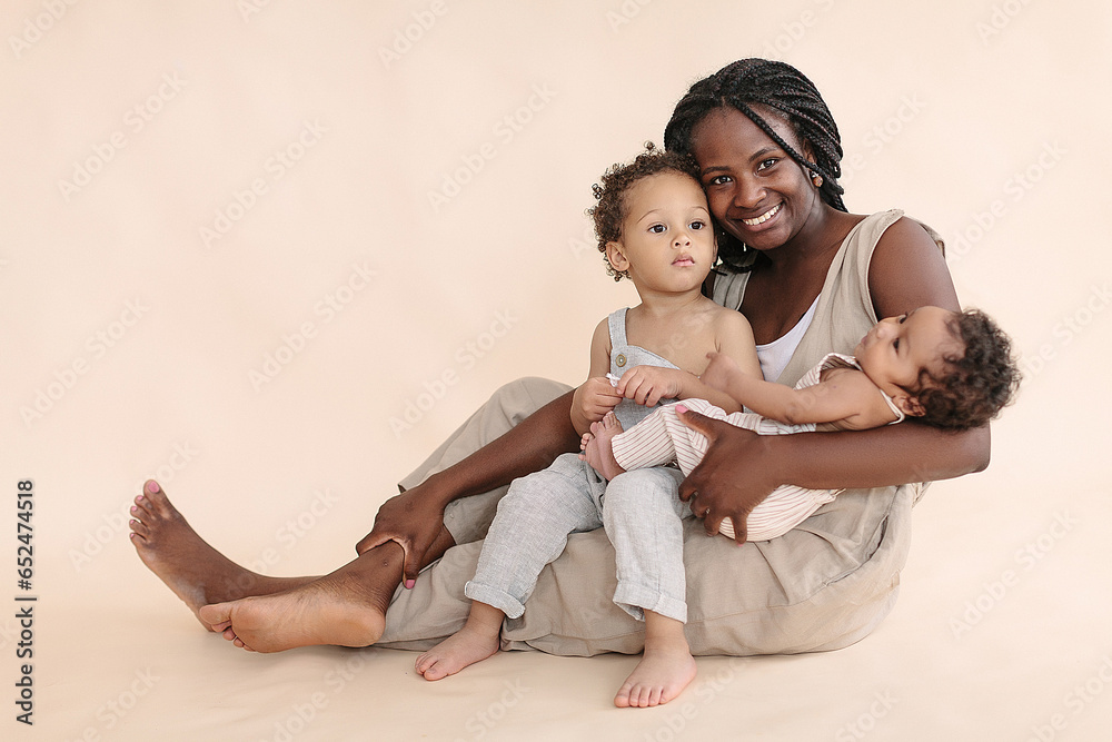 African-American baby and child with mother on a beige background in the style of minimalism African-American baby and child with mother on a beige background in the style of minimalism