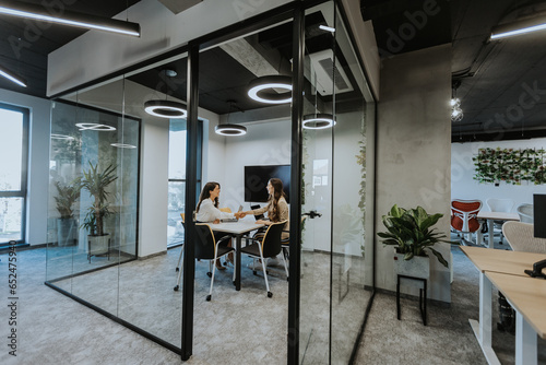 Photography Young business women discussing in cubicle at the office