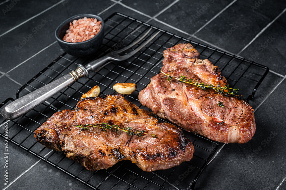BBQ Grilled Pork loin steaks, neck meat. Black background. Top view