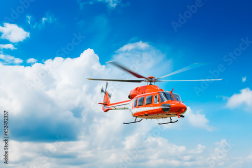 Closeup of flying red helicopter ln blue sky background. Air rescue. Helicopter for rescue.