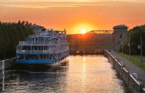 Cruise steamship passes through the gateway of the Moscow Canal at sunset