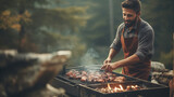  A young man grilling outdoors. Comfortable grill for grilling meat and picnic. 