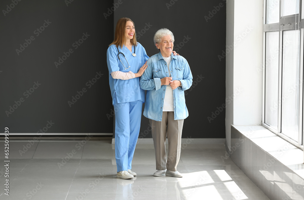 Female caregiver with senior woman in room Female caregiver with senior woman in room
