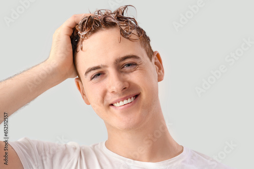 Young man washing hair agai...