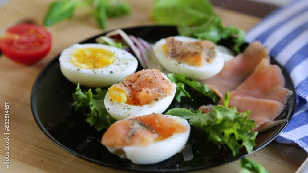 boiled eggs with salted red fish, herbs and seasonings in a plate . boiled eggs with salted red fish, herbs and seasonings in a plate .