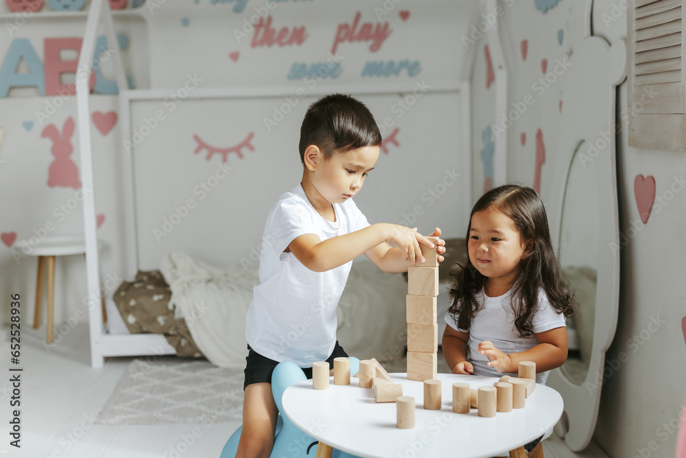 Εκτύπωση καμβά children boy and girl play with wooden toys at home in children's bedroom