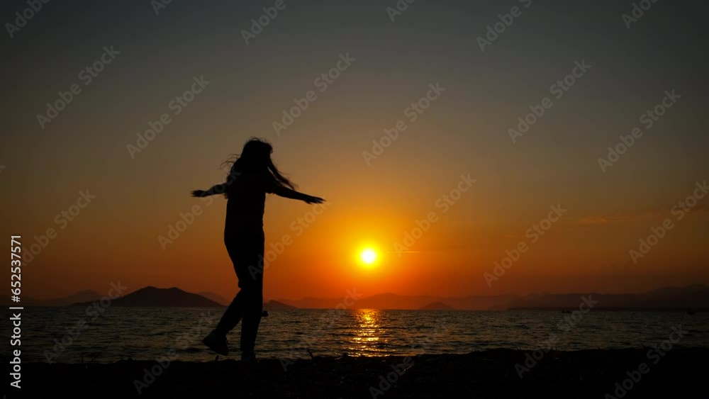 Teen silhouette jump in the dusk. A view of dancing and jumping teen silhouette on the evening beach during vacation time. Teen silhouette jump in the dusk. A view of dancing and jumping teen silhouette on the evening beach during vacation time.