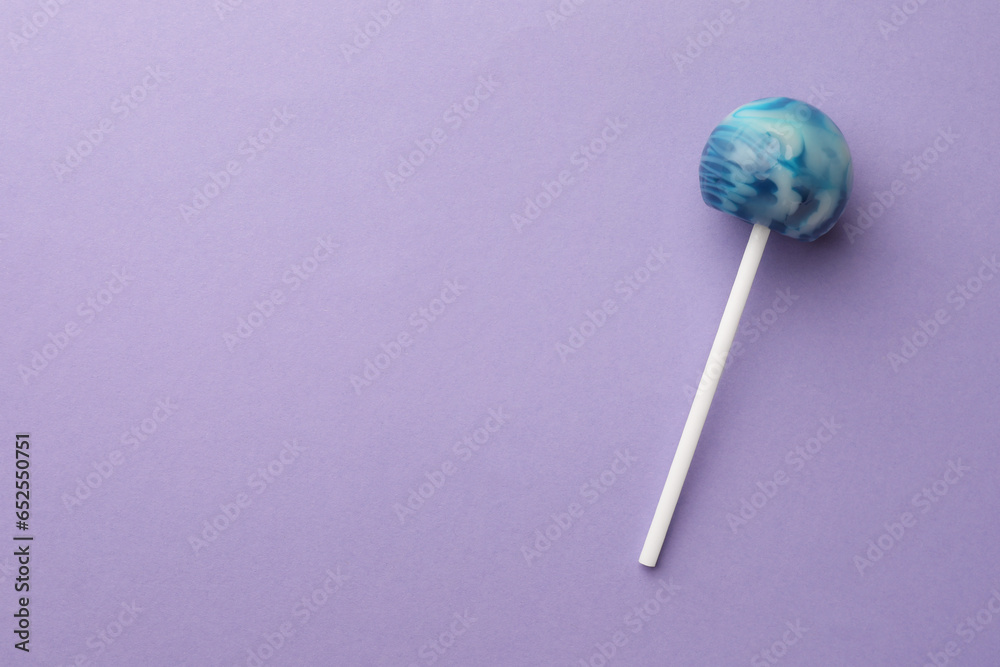 Tasty lollipop on violet background, top view. Space for text Tasty lollipop on violet background, top view. Space for text