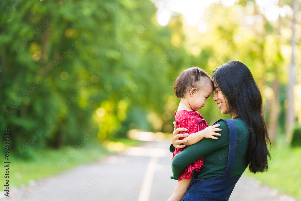 Asian mom and daughter enjoying nature in park outdoor with sunlight, heartwarming bond, family time, mothers day concept, joyful family day, mother day picnic, thai ethnicity Asian mom and daughter enjoying nature in park outdoor with sunlight, heartwarming bond, family time, mothers day concept, joyful family day, mother day picnic, thai ethnicity