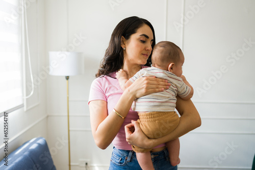 Tableau sur toile Loving mother with her baby burping gas