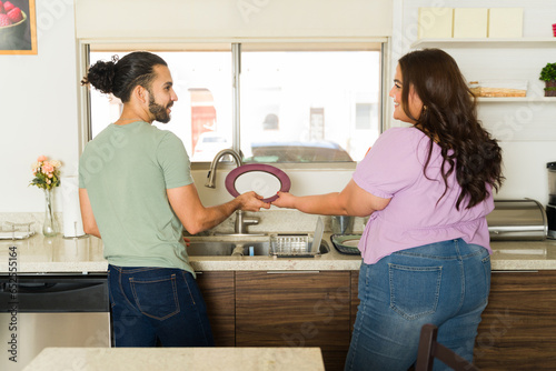Fotografie Boyfriend and girlfriend doing the dishes and sharing house chores