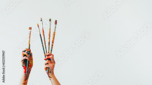 Artist equipment. Painting brush. Woman painter hands holding set of messy colorful paintbrushes isolated on white empty space background.
