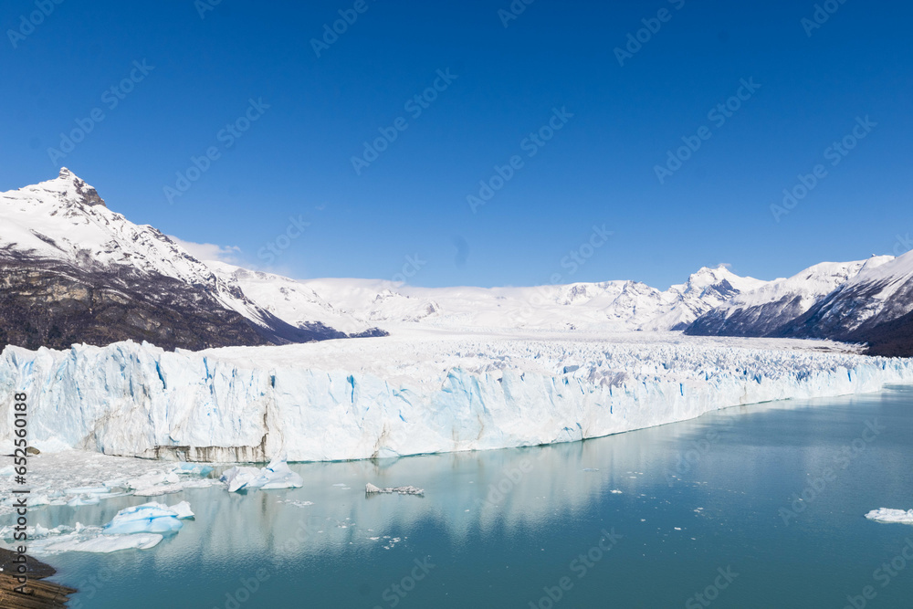 Capture the full majesty of Glaciar Perito Moreno in one stunning image. In this breathtaking photo, the mighty glacier rises majestically above the waters of Lake Argentino in El Calafate, Argentina.
